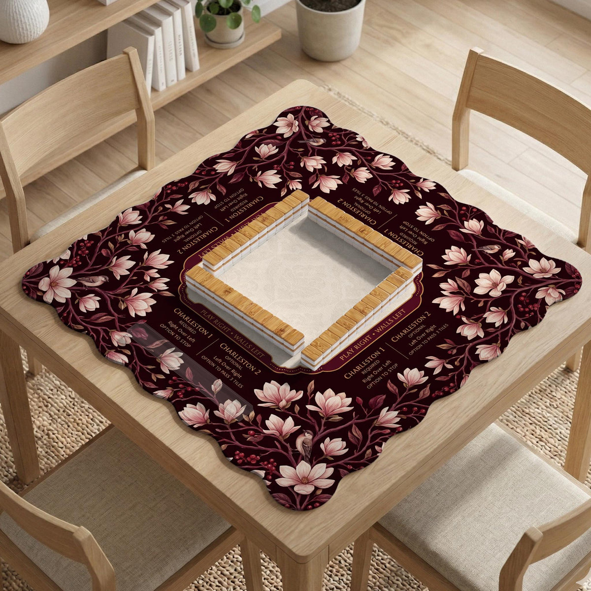 Cream American mahjong mat with a burgundy border of pale pink magnolia blossoms and printed play-direction and passing reminders.