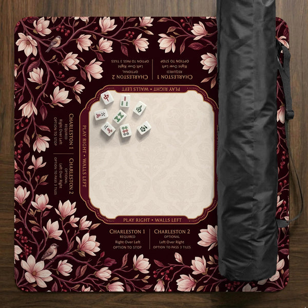 Cream American mahjong mat with a burgundy border of pale pink magnolia blossoms and printed play-direction and passing reminders.