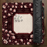 Cream American mahjong mat with a burgundy border of pale pink magnolia blossoms and printed play-direction and passing reminders.