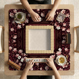 Cream American mahjong mat with a burgundy border of pale pink magnolia blossoms and printed play-direction and passing reminders.