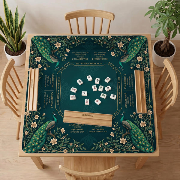 American mahjong mat with a deep teal-green background, peacocks, small cream flowers, leafy branches, and printed play-direction and Charleston reminders.