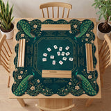 American mahjong mat with a deep teal-green background, peacocks, small cream flowers, leafy branches, and printed play-direction and Charleston reminders.