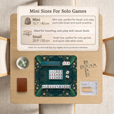 American mahjong mat with a deep teal-green background, peacocks, small cream flowers, leafy branches, and printed play-direction and Charleston reminders.