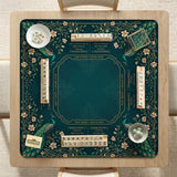 American mahjong mat with a deep teal-green background, peacocks, small cream flowers, leafy branches, and printed play-direction and Charleston reminders.