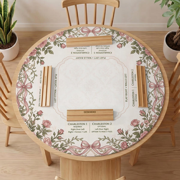 American mahjong mat with an ivory center, printed play-direction reminders, and a border of dusty-pink roses, ribbon bows, and green leaves.