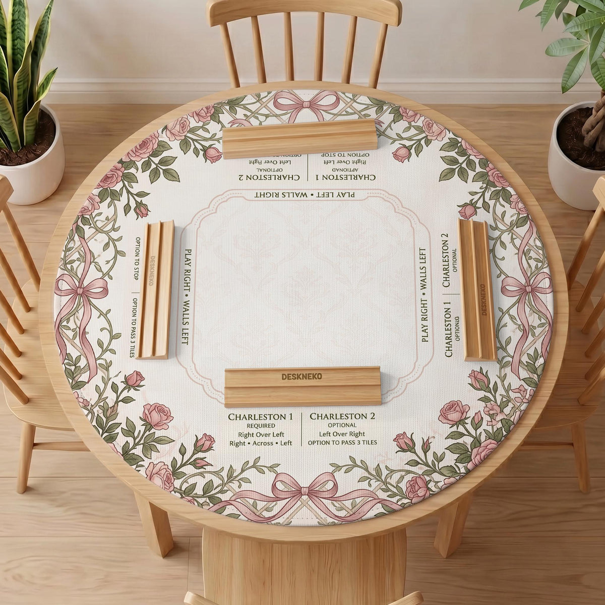 American mahjong mat with an ivory center, printed play-direction reminders, and a border of dusty-pink roses, ribbon bows, and green leaves.