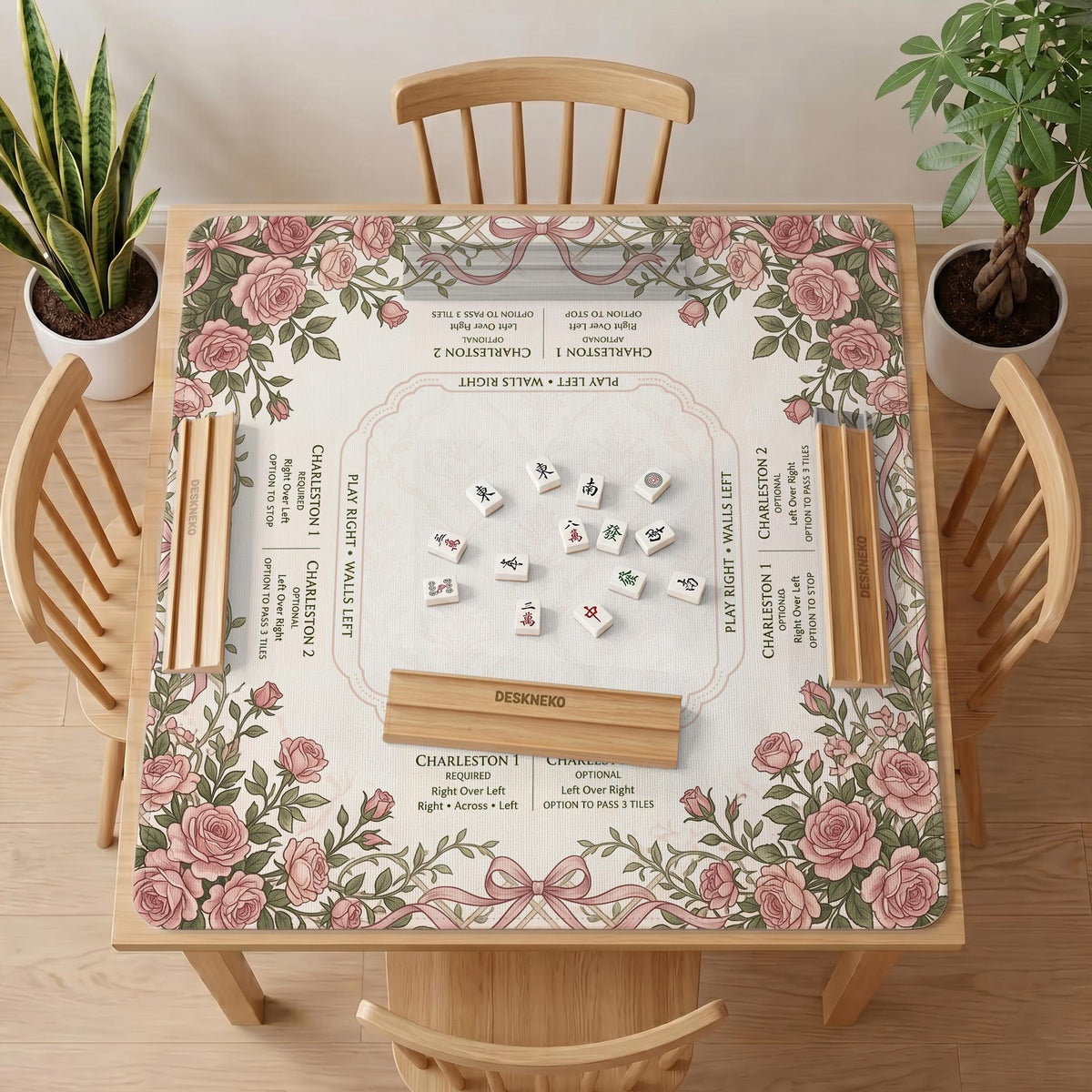 American mahjong mat with an ivory center, printed play-direction reminders, and a border of dusty-pink roses, ribbon bows, and green leaves.