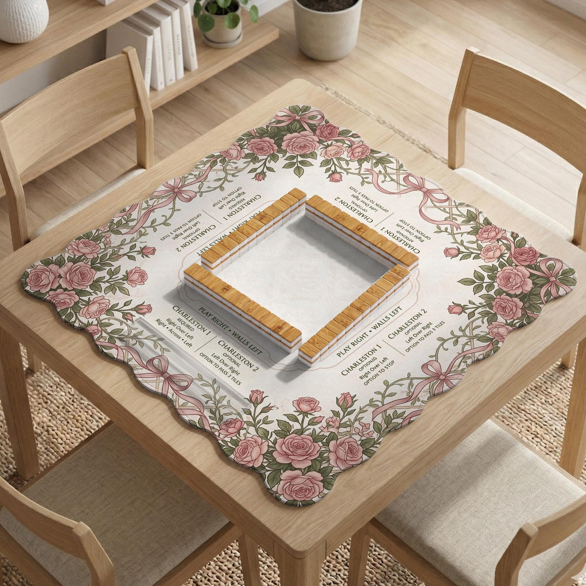 American mahjong mat with an ivory center, printed play-direction reminders, and a border of dusty-pink roses, ribbon bows, and green leaves.