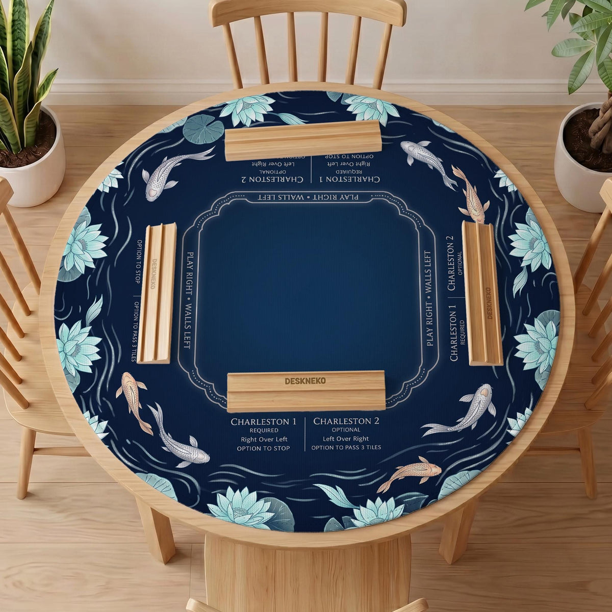 American mahjong mat with a navy-blue pond design, pale aqua lotus flowers, flowing water lines, koi fish, and printed play-direction and Charleston passing reminders.
