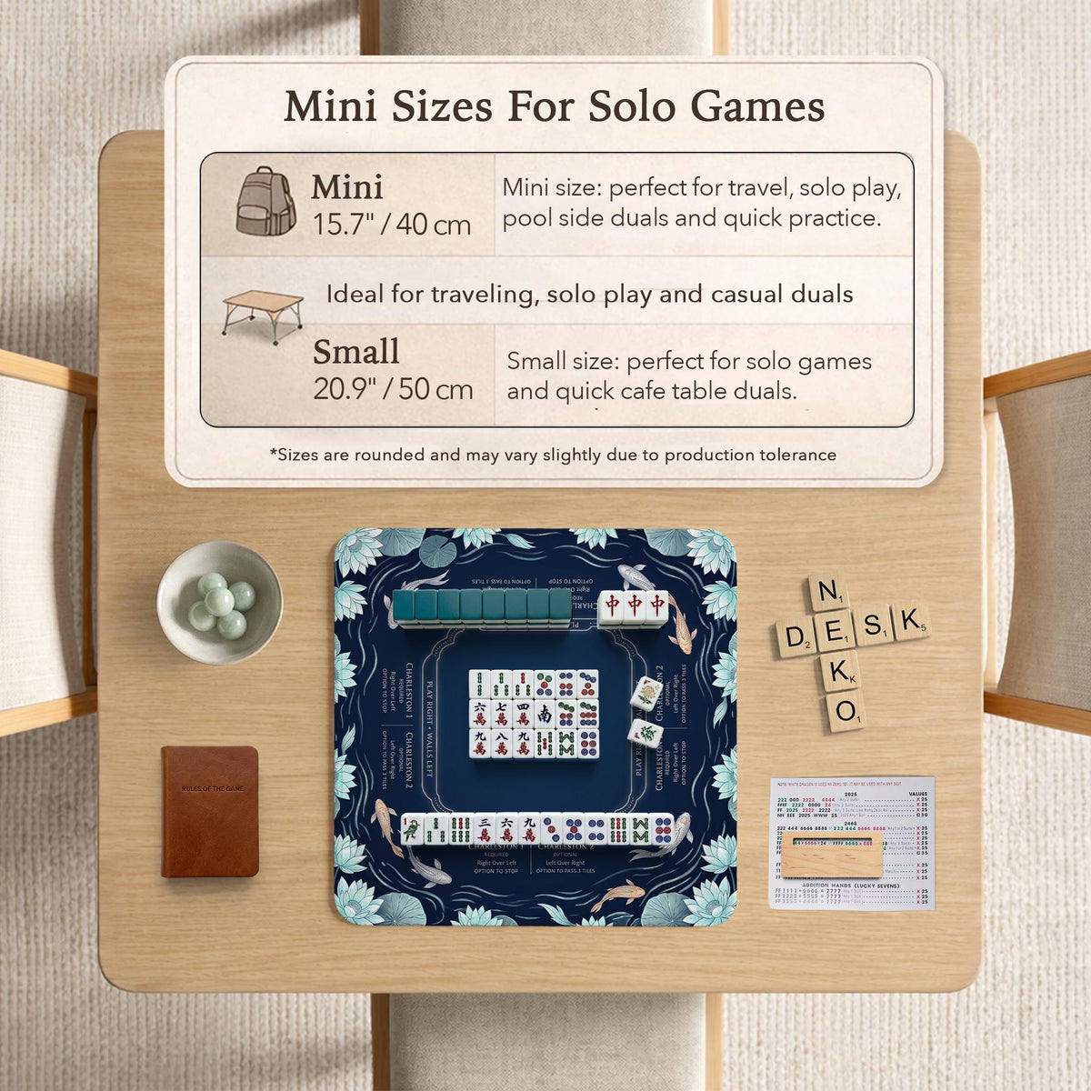 American mahjong mat with a navy-blue pond design, pale aqua lotus flowers, flowing water lines, koi fish, and printed play-direction and Charleston passing reminders.