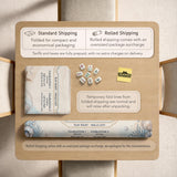 American mahjong mat with a cream center and a coastal border showing oyster shells, scallop shells, starfish, pearl strands, and pale blue sea plants.