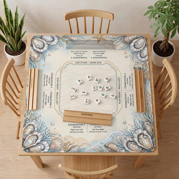 American mahjong mat with a cream center and a coastal border showing oyster shells, scallop shells, starfish, pearl strands, and pale blue sea plants.