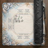 American mahjong mat with a cream center and a coastal border showing oyster shells, scallop shells, starfish, pearl strands, and pale blue sea plants.