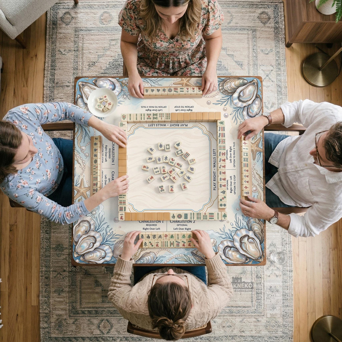 American mahjong mat with a cream center and a coastal border showing oyster shells, scallop shells, starfish, pearl strands, and pale blue sea plants.