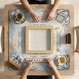 American mahjong mat with a cream center and a coastal border showing oyster shells, scallop shells, starfish, pearl strands, and pale blue sea plants.