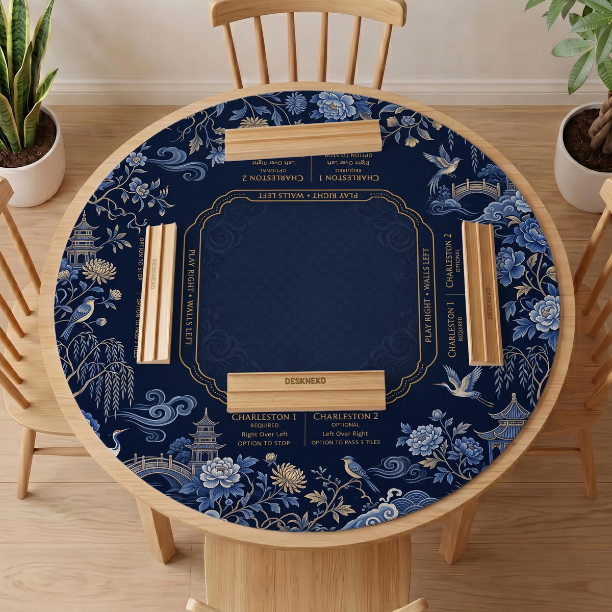 Navy mahjong mat with cranes, garden birds, pagodas, and blue and cream floral designs around a framed playing area with a printed Charleston guide.