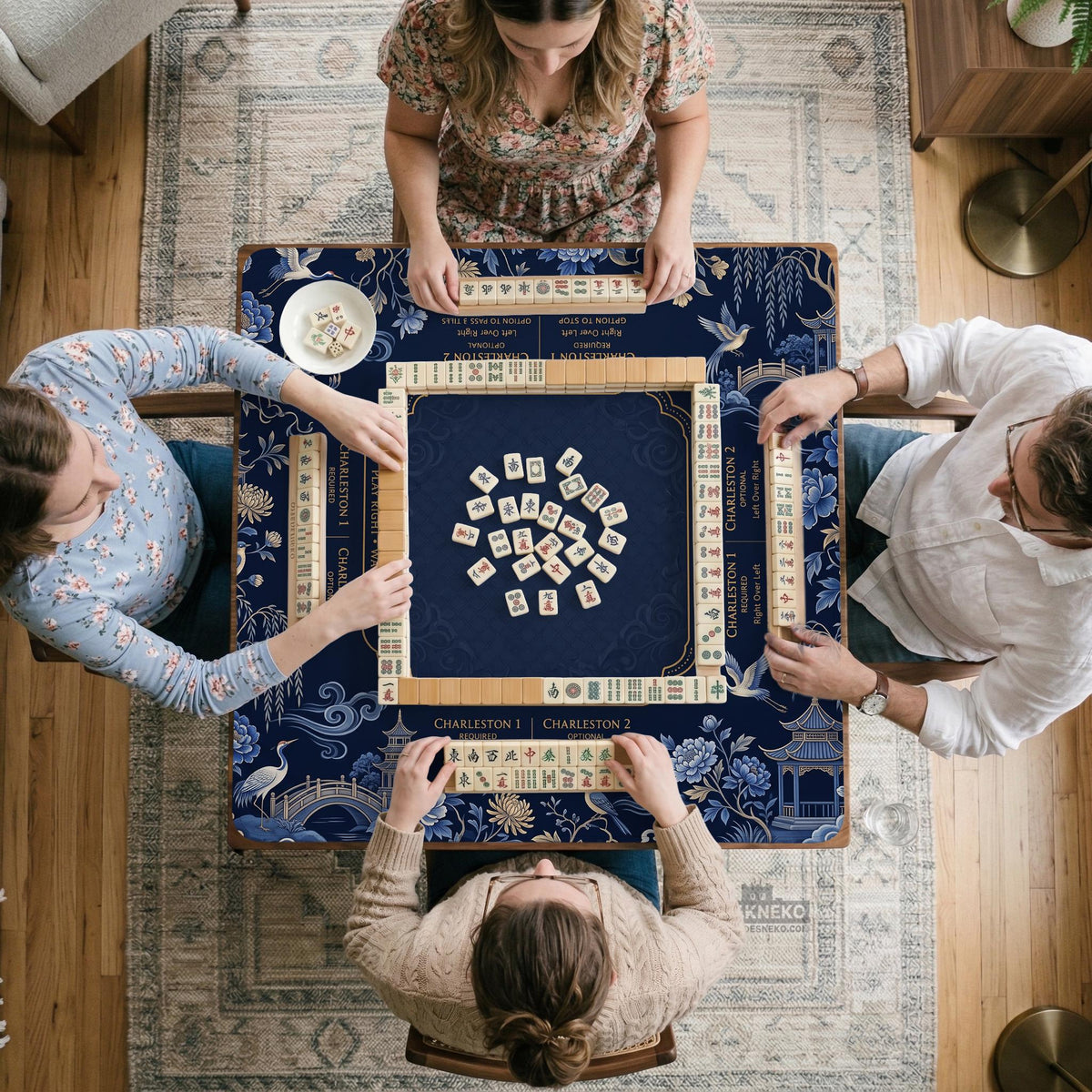 Navy mahjong mat with cranes, garden birds, pagodas, and blue and cream floral designs around a framed playing area with a printed Charleston guide.