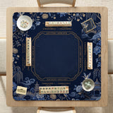 Navy mahjong mat with cranes, garden birds, pagodas, and blue and cream floral designs around a framed playing area with a printed Charleston guide.