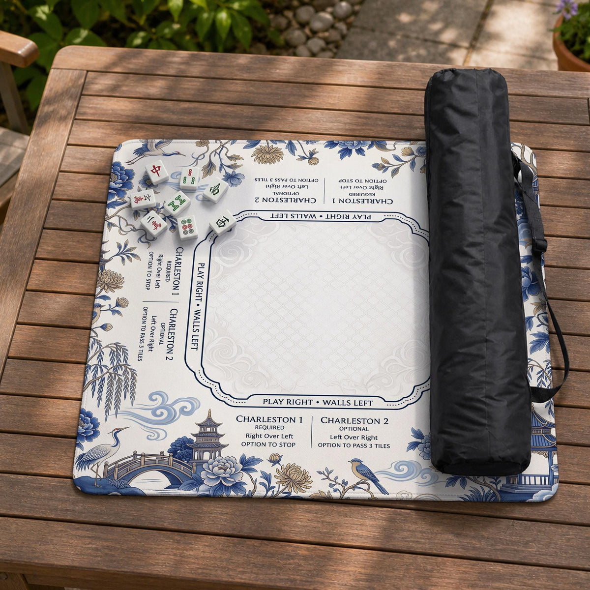 Square ivory mahjong mat with blue cranes, pagodas, flowers, and a blue border around the playing area.