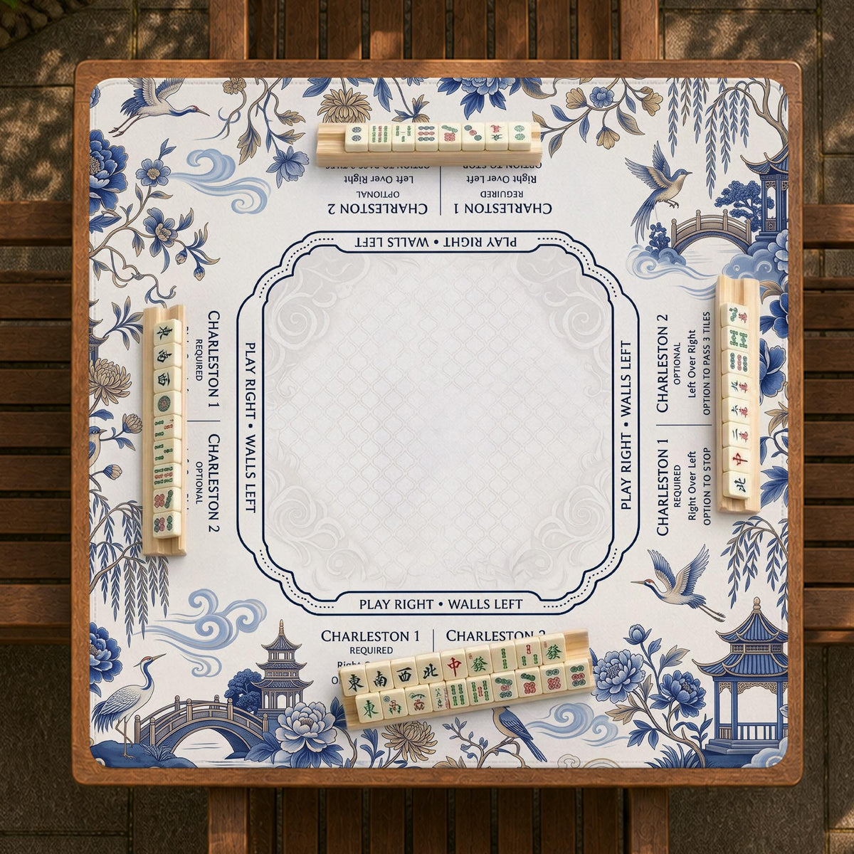 Square ivory mahjong mat with blue cranes, pagodas, flowers, and a blue border around the playing area.