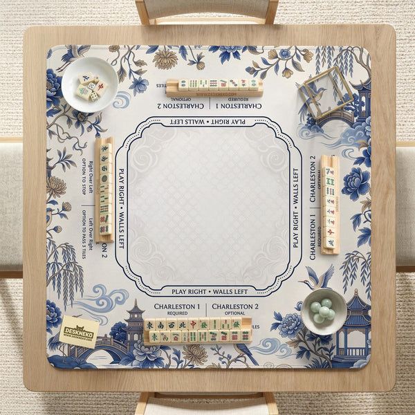 Square ivory mahjong mat with blue cranes, pagodas, flowers, and a blue border around the playing area.