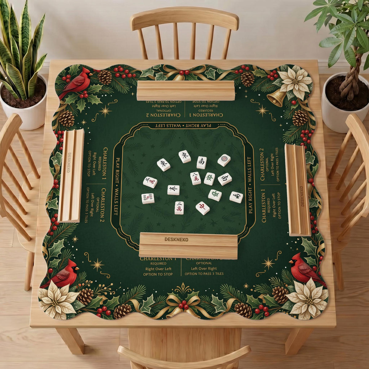 Green mahjong mat with red cardinals, holly berries, cream poinsettias, and gold seasonal details around a printed Charleston guide.