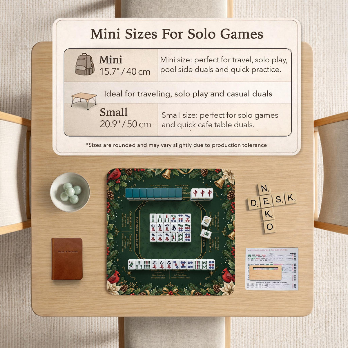 Green mahjong mat with red cardinals, holly berries, cream poinsettias, and gold seasonal details around a printed Charleston guide.