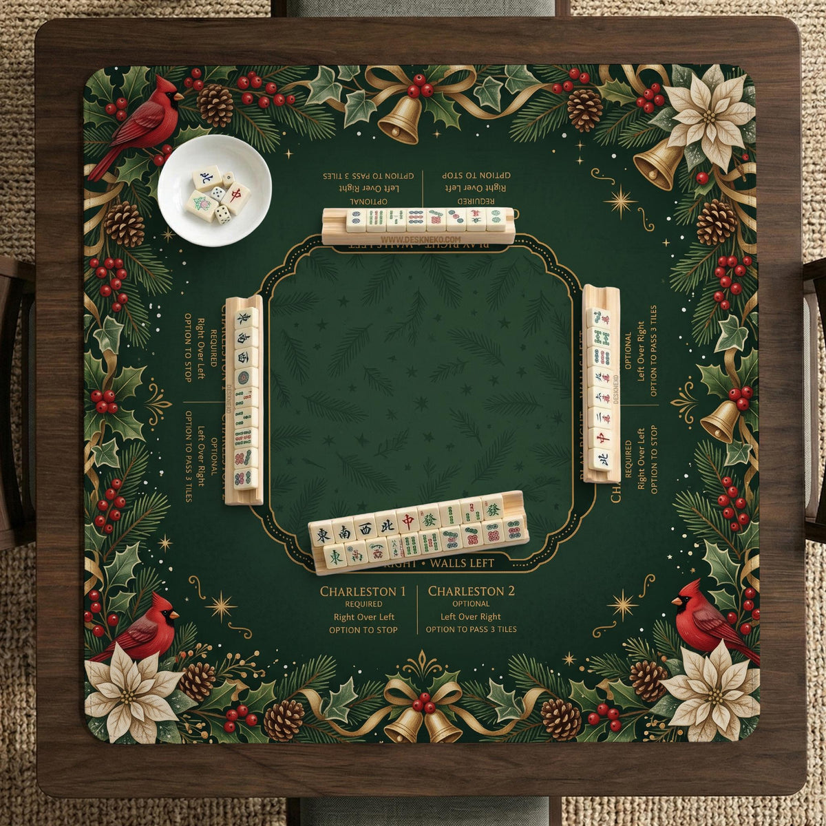Green mahjong mat with red cardinals, holly berries, cream poinsettias, and gold seasonal details around a printed Charleston guide.