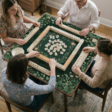 Square mahjong mat with a forest green botanical design, fern leaves, small cream flowers, and a printed Charleston guide around the center area.