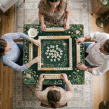 Square mahjong mat with a forest green botanical design, fern leaves, small cream flowers, and a printed Charleston guide around the center area.