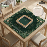 Square mahjong mat with a forest green botanical design, fern leaves, small cream flowers, and a printed Charleston guide around the center area.