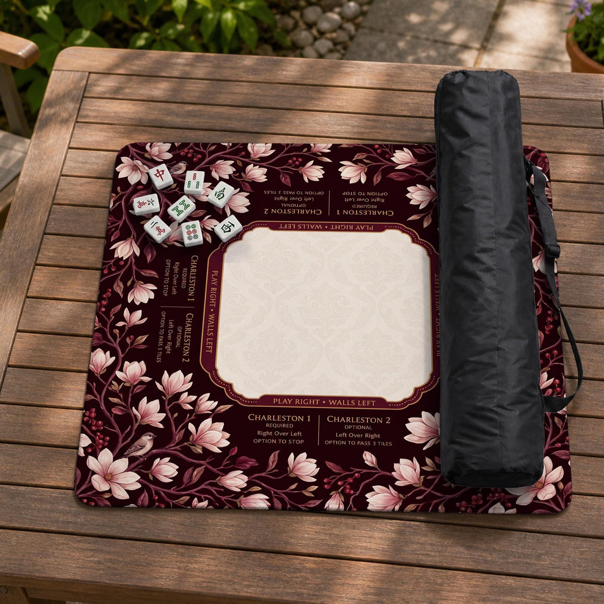 Cream American mahjong mat with a burgundy border of pale pink magnolia blossoms and printed play-direction and passing reminders.