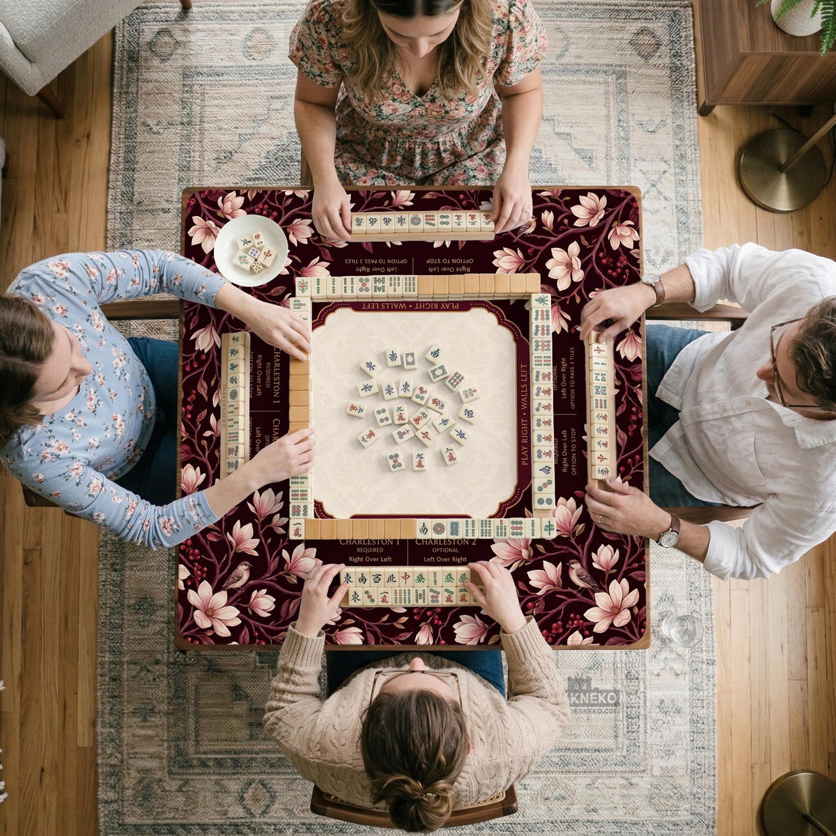 Cream American mahjong mat with a burgundy border of pale pink magnolia blossoms and printed play-direction and passing reminders.