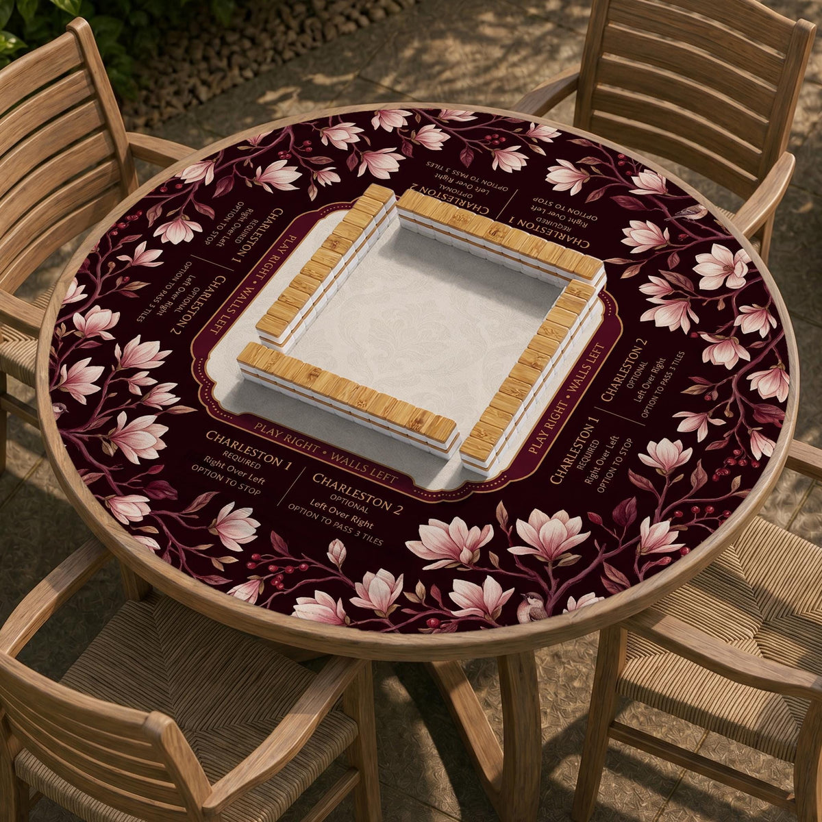 Cream American mahjong mat with a burgundy border of pale pink magnolia blossoms and printed play-direction and passing reminders.