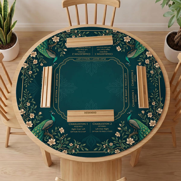American mahjong mat with a deep teal-green background, peacocks, small cream flowers, leafy branches, and printed play-direction and Charleston reminders.
