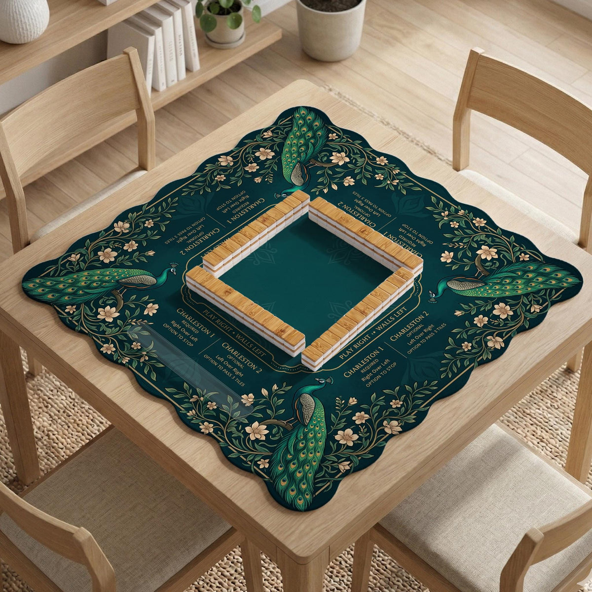 American mahjong mat with a deep teal-green background, peacocks, small cream flowers, leafy branches, and printed play-direction and Charleston reminders.