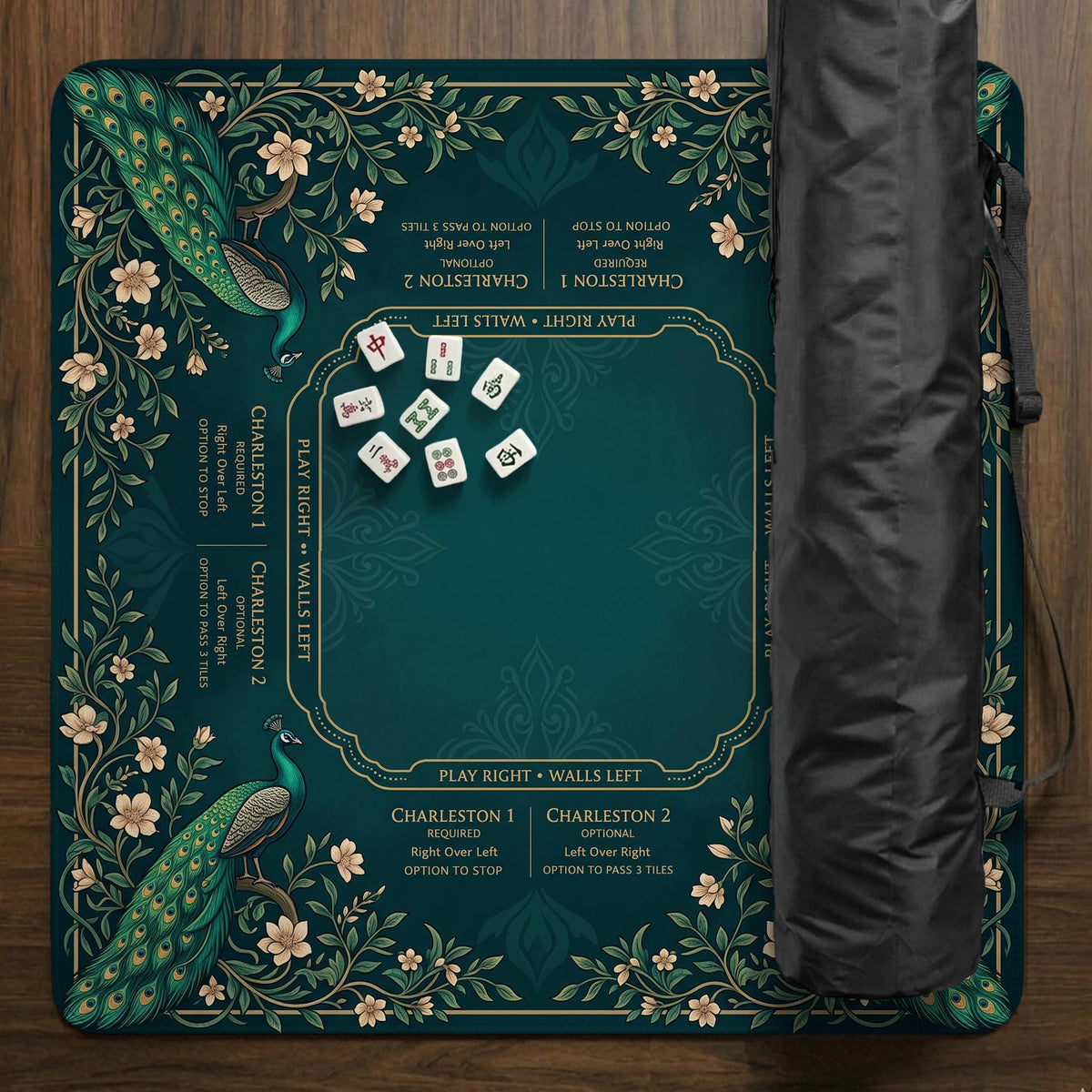 American mahjong mat with a deep teal-green background, peacocks, small cream flowers, leafy branches, and printed play-direction and Charleston reminders.