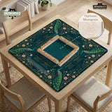 American mahjong mat with a deep teal-green background, peacocks, small cream flowers, leafy branches, and printed play-direction and Charleston reminders.