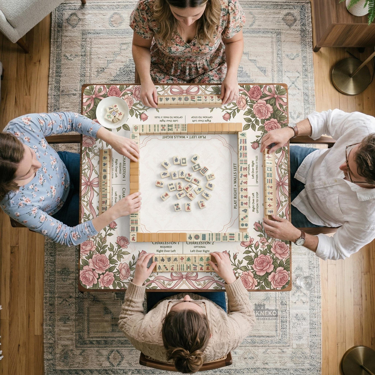 American mahjong mat with an ivory center, printed play-direction reminders, and a border of dusty-pink roses, ribbon bows, and green leaves.