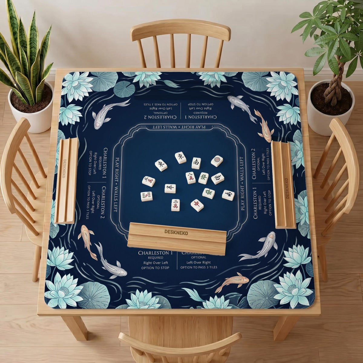 American mahjong mat with a navy-blue pond design, pale aqua lotus flowers, flowing water lines, koi fish, and printed play-direction and Charleston passing reminders.