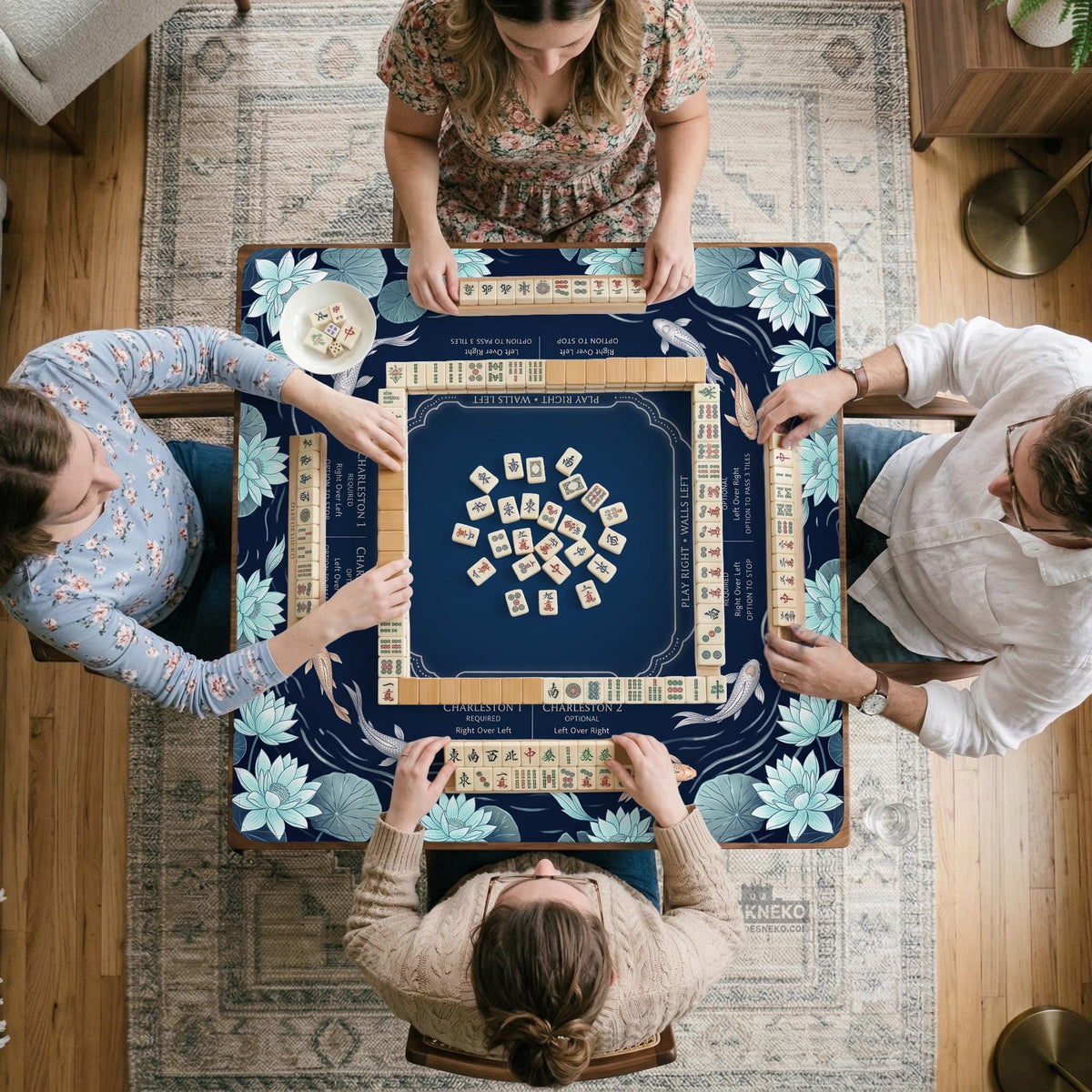 American mahjong mat with a navy-blue pond design, pale aqua lotus flowers, flowing water lines, koi fish, and printed play-direction and Charleston passing reminders.