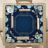 American mahjong mat with a navy-blue pond design, pale aqua lotus flowers, flowing water lines, koi fish, and printed play-direction and Charleston passing reminders.