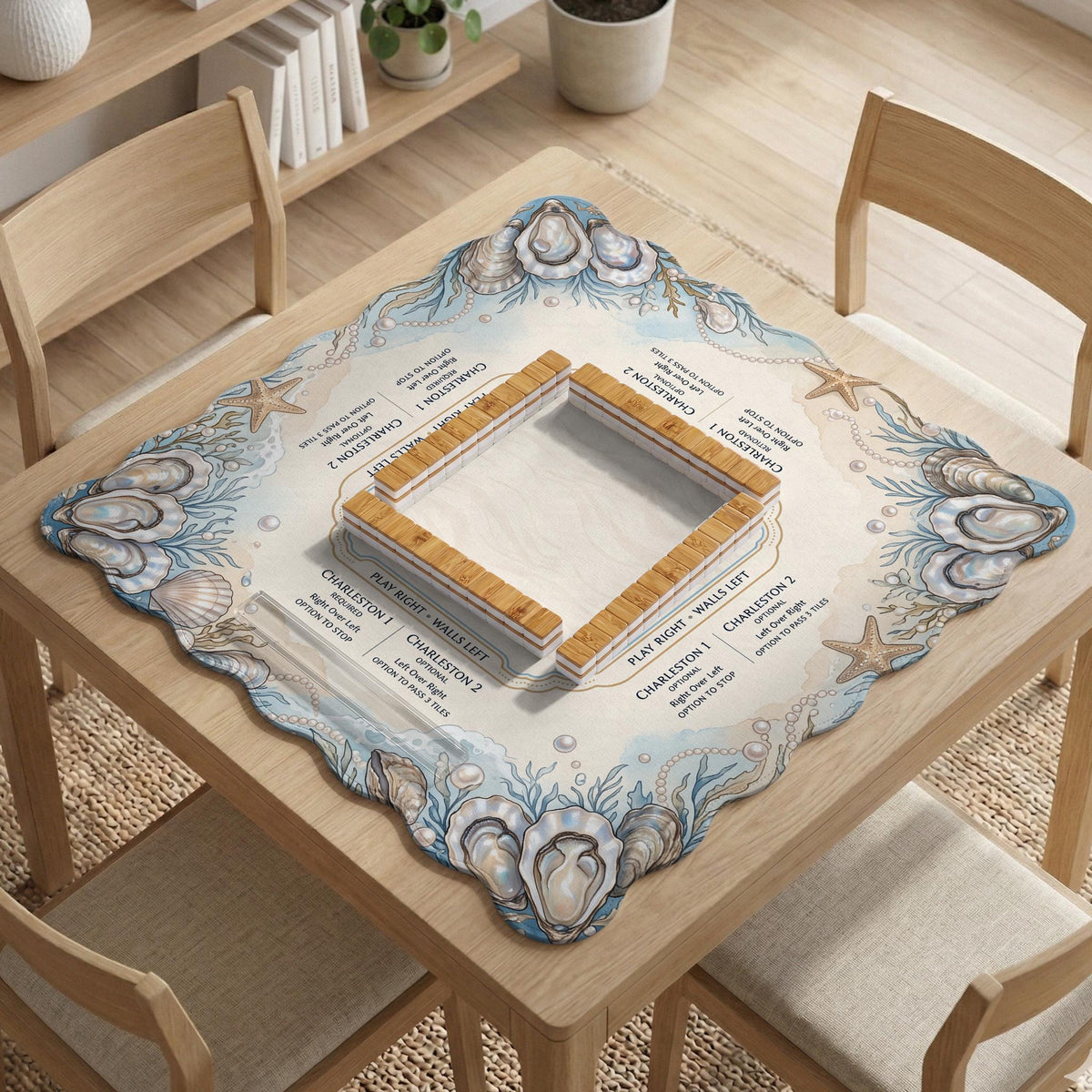 American mahjong mat with a cream center and a coastal border showing oyster shells, scallop shells, starfish, pearl strands, and pale blue sea plants.